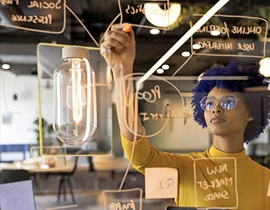 Mujer creando un esquema sobre pantalla de cristal.