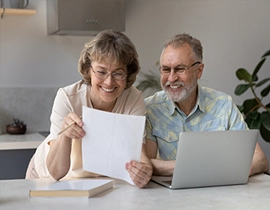 Un hombre y una mujer de mediana edad leyendo unos papeles