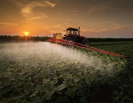 Máquina agrícola en un campo pulverizando.