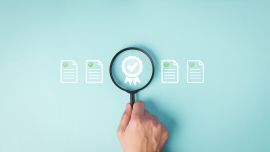 Mano con una lupa sobre fondo azul
