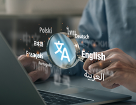 Persona trabajando con un portátil e iconos sobre sus manos con nombres de lenguas distintas alrededor de una lupa